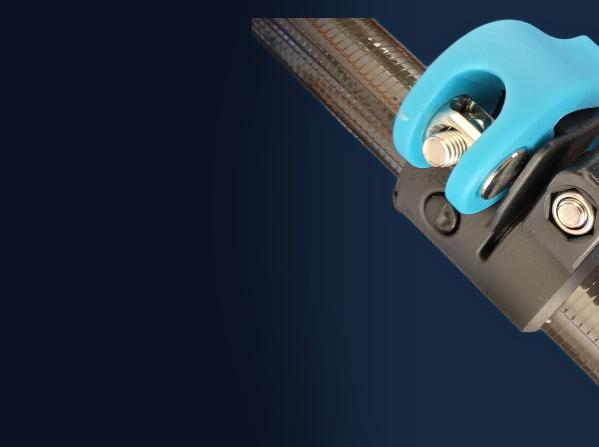 Close-up of an UltraREACH Anti-Spin clamp, its teal lever open against the black clamp body, on a carbon fibre pole section.
